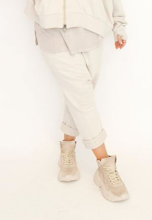 Women's relaxed drop rise pant featuring side pockets and an elastic waistband. Made in a French Terry fabric. In colour creme by Sort Aarhus. Front view.