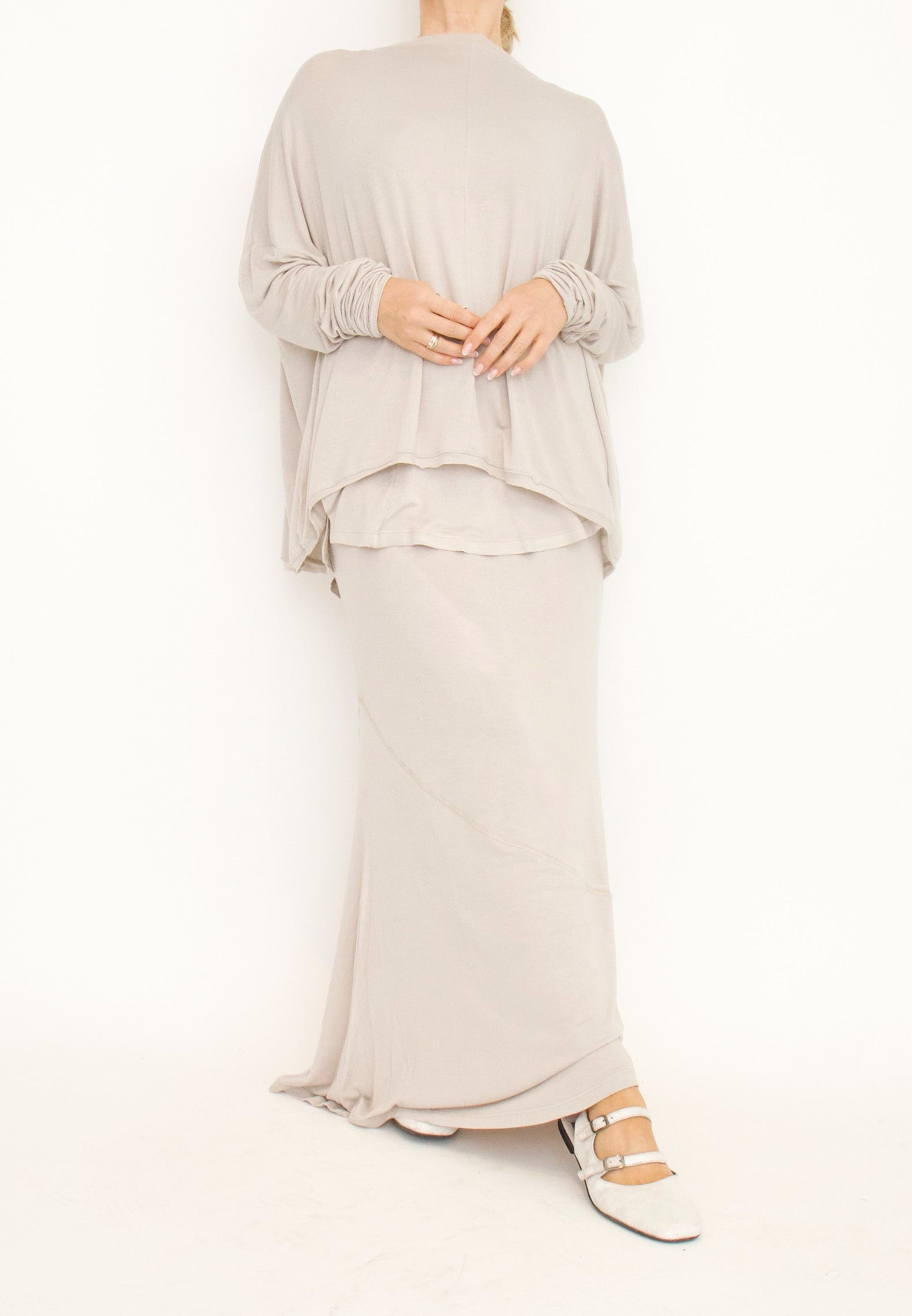 Women's floor length, elasticized waist, double-layered skirt, made from a light and stretchy viscose blend fabric by Sort Aarhus. In colour creme. Front view.