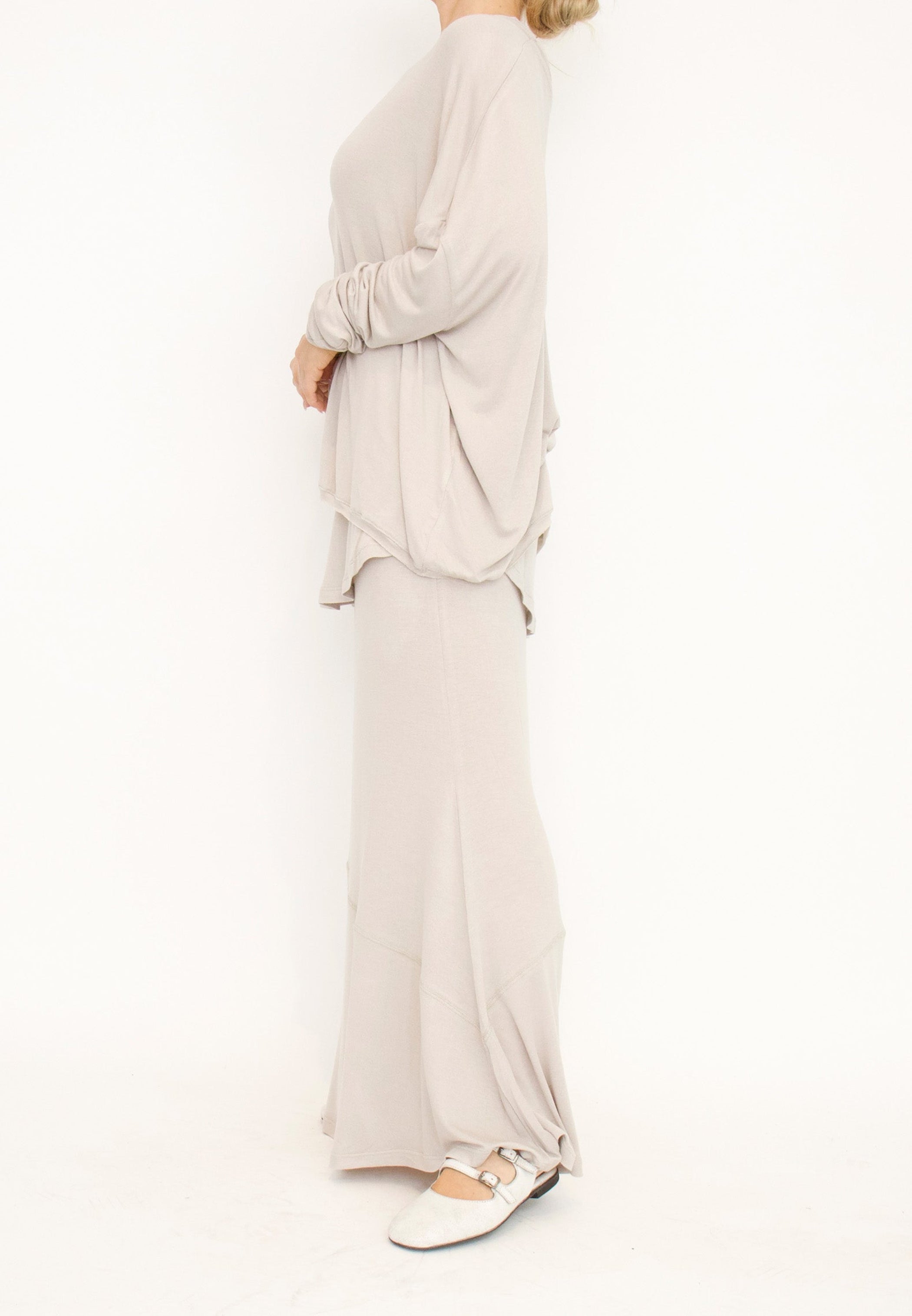 Women's floor length, elasticized waist, double-layered skirt, made from a light and stretchy viscose blend fabric by Sort Aarhus. In colour creme. Side view.