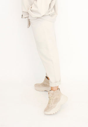 Women's relaxed drop rise pant featuring side pockets and an elastic waistband. Made in a French Terry fabric. In colour creme by Sort Aarhus. Side view.