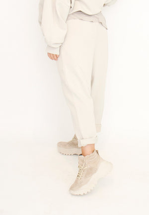 Women's relaxed drop rise pant featuring side pockets and an elastic waistband. Made in a French Terry fabric. In colour creme by Sort Aarhus. Front view. Back view.