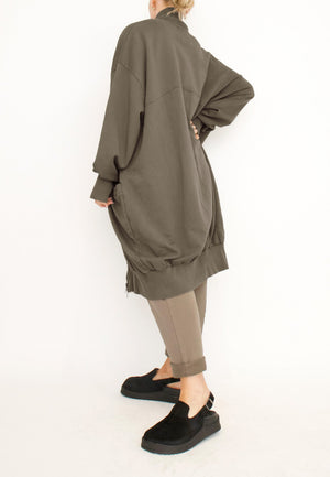 Women's long zip up cardigan, with long sleeves, ribbed collar, cocoon shaped silhouette and pockets. Made in French Terry fabric by Sort Aarhus. Colour khaki. Side view.