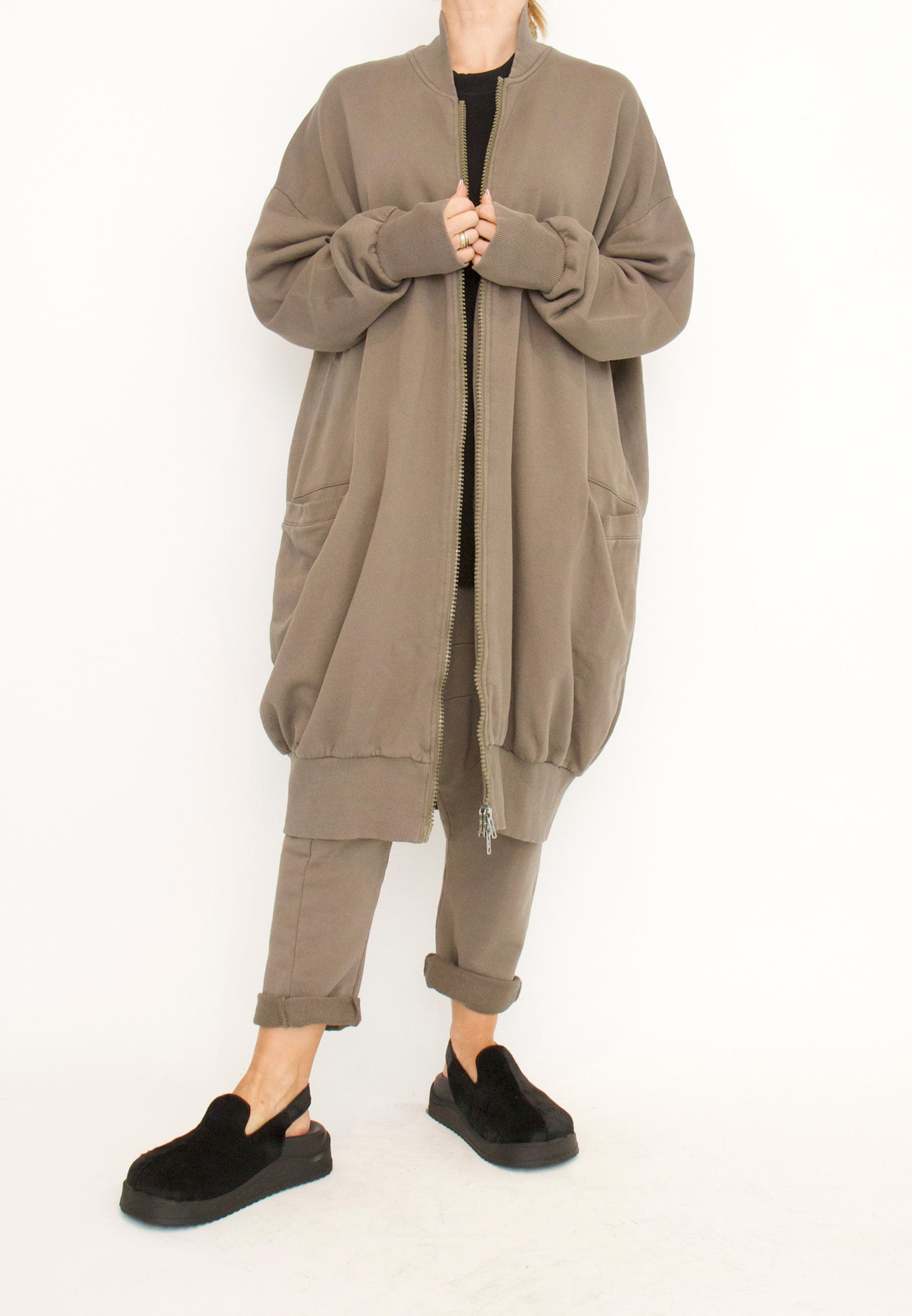 Women's long zip up cardigan, with long sleeves, ribbed collar, cocoon shaped silhouette and pockets. Made in French Terry fabric by Sort Aarhus. Un-zipped view.