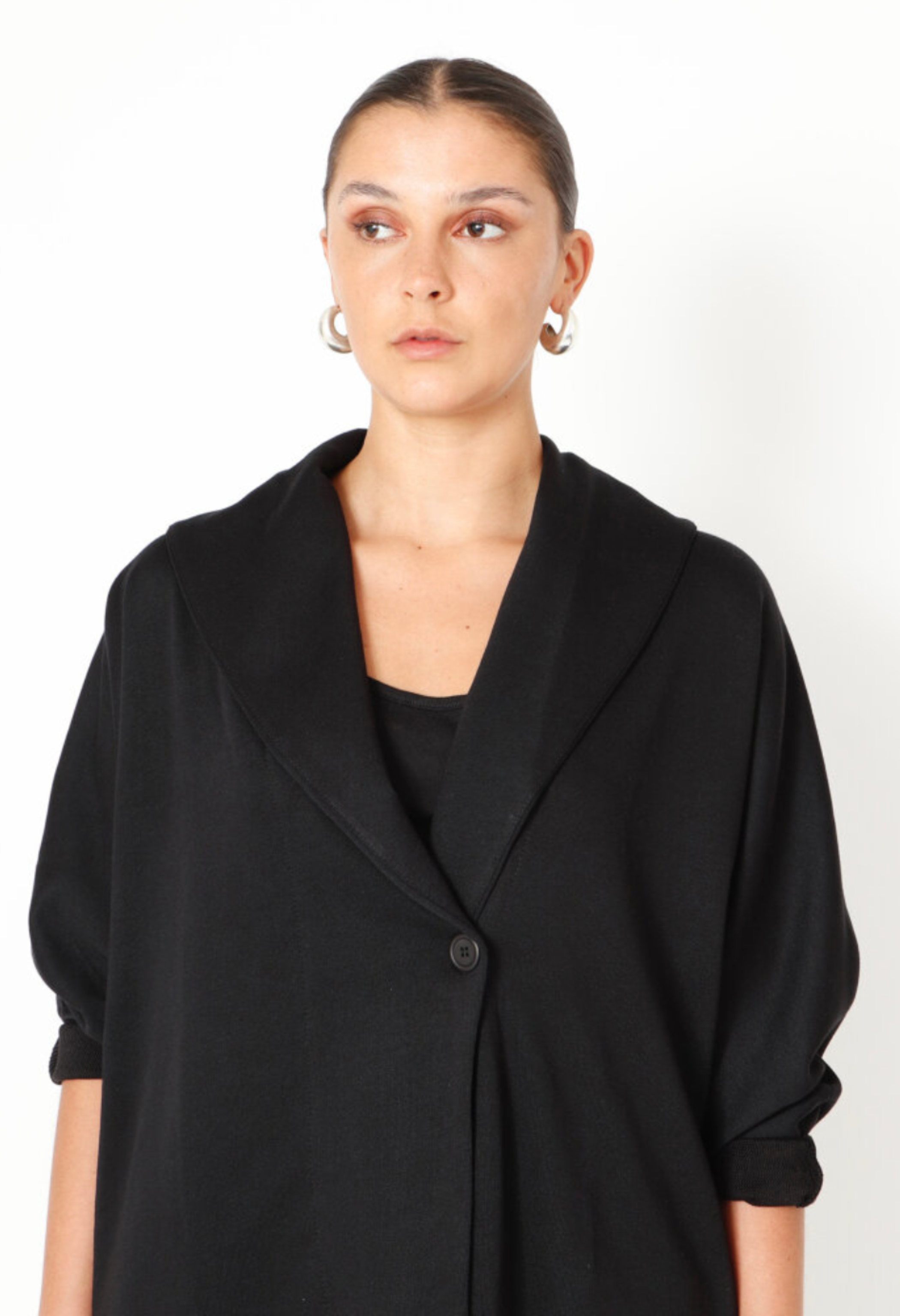 Women's boxy cardigan with a relaxed fit, button closure, and a casual collar. Made in a French Terry fabric. In colour black by Sort Aarhus. Close up view.