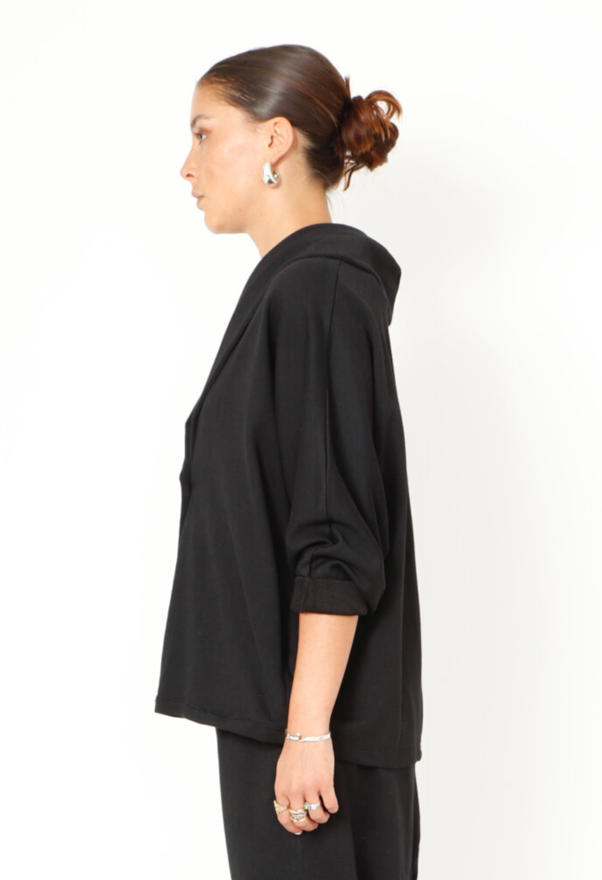Women's boxy cardigan with a relaxed fit, button closure, and a casual collar. Made in a French Terry fabric. In colour black by Sort Aarhus. Side view.