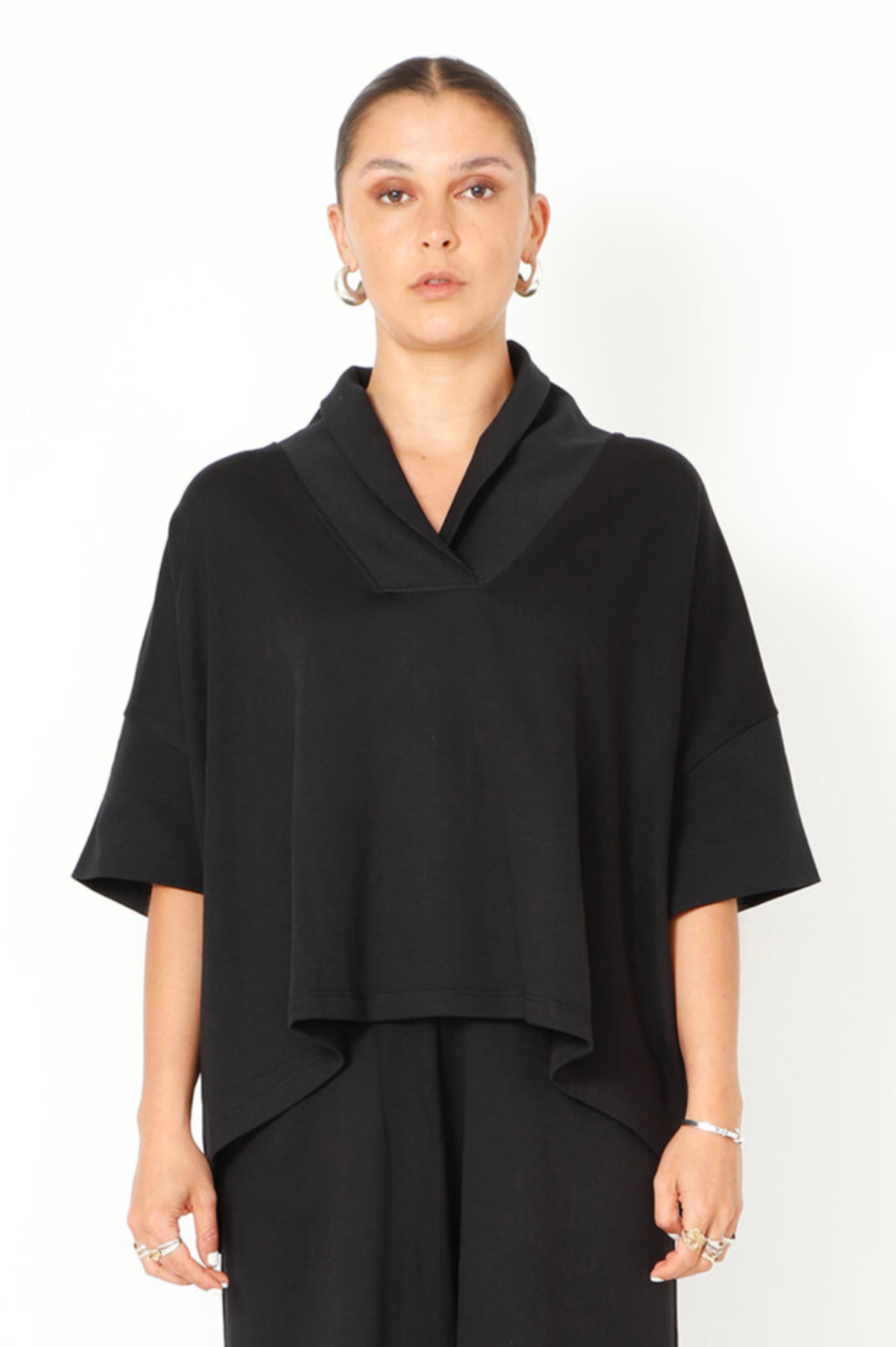 Women's boxy relaxed 1/2 sleeve blouse, with a wide, soft collar, made in a French Terry fabric. In colour black from Sort Aarhus. Front view.