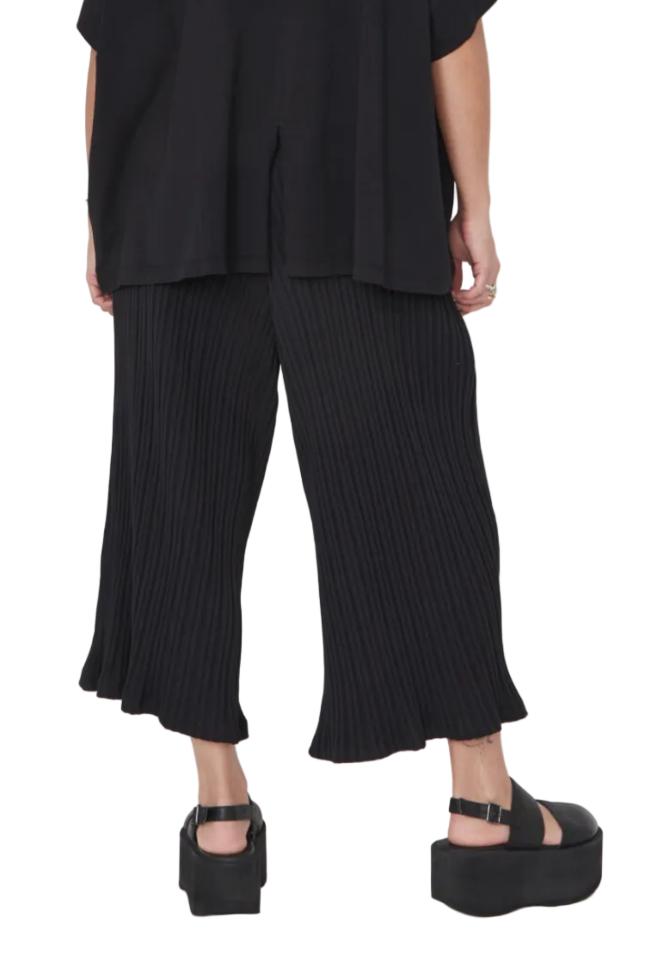 Women's cropped 3/4 length wide leg pant, with a wide elastic waistband, and pockets. Made in a stretchy rib textured organic cotton. Colour black by Sort Aarhus. Back view.