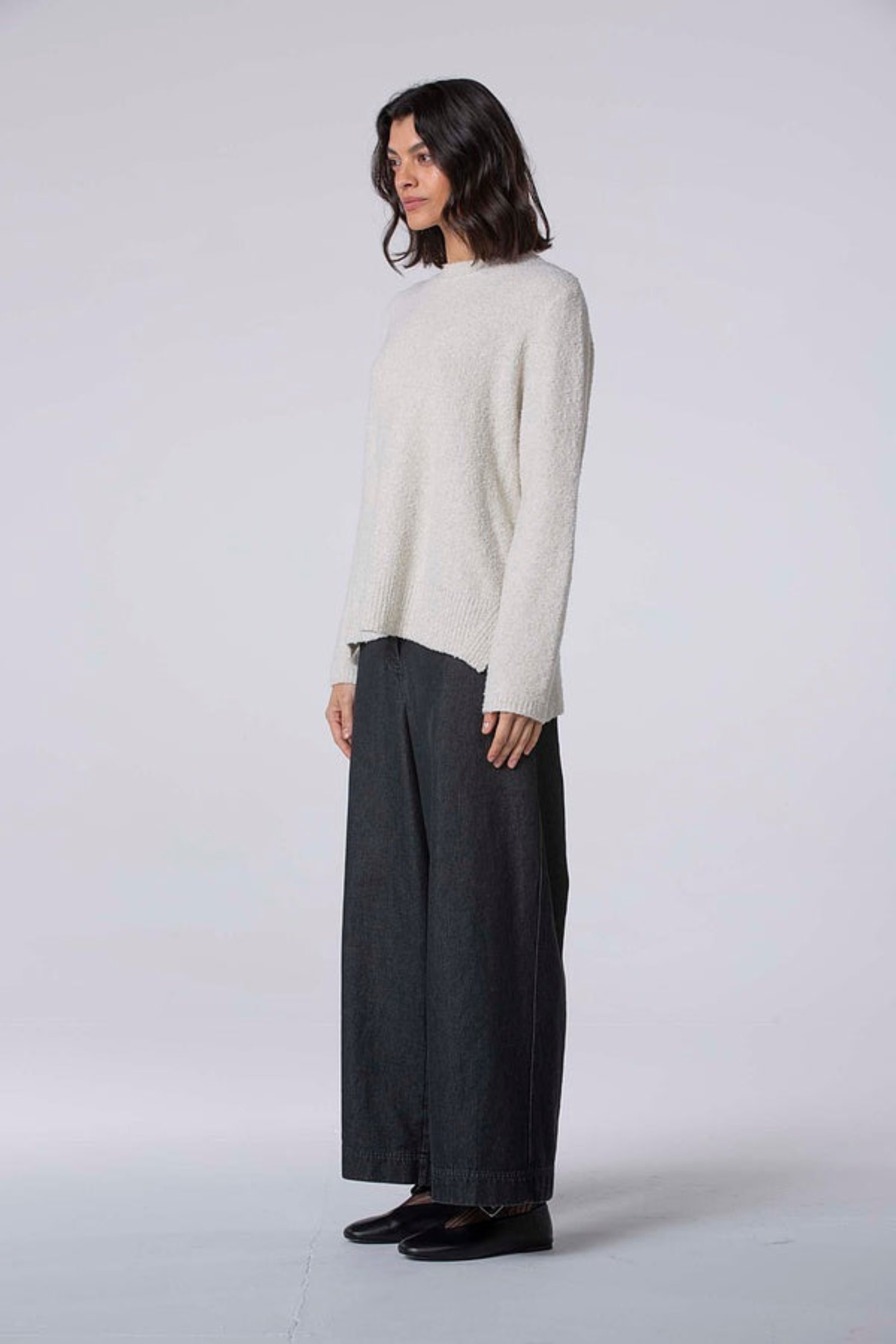 Women's wide leg pant with flat front button closure, curved front slash pockets and back patch pockets. Made in a denim fabric from Oska. In colour black. Side view.