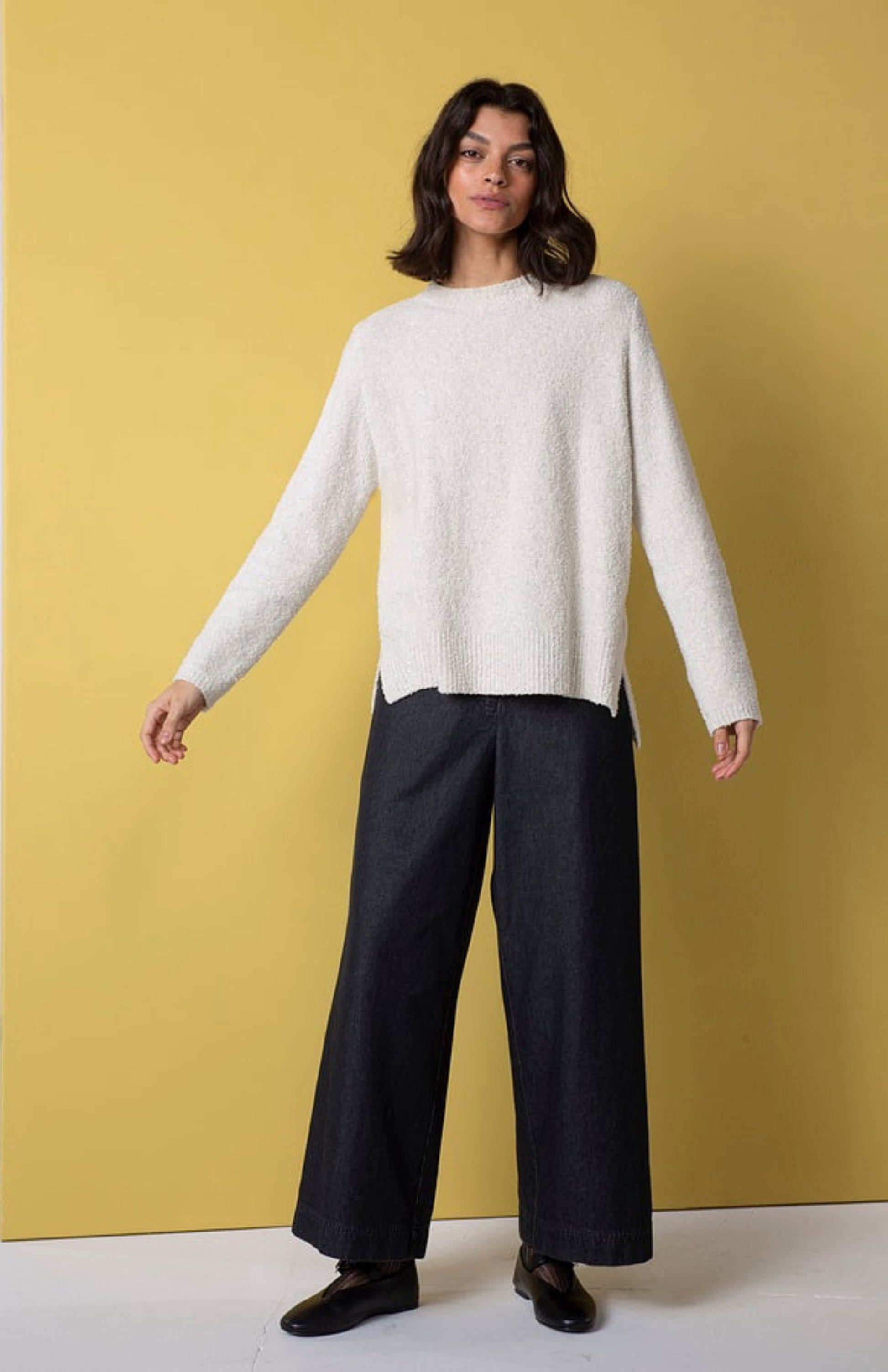 Women's wide leg pant with flat front button closure, curved front slash pockets and back patch pockets. Made in a denim fabric from Oska. In colour black. Full front view.