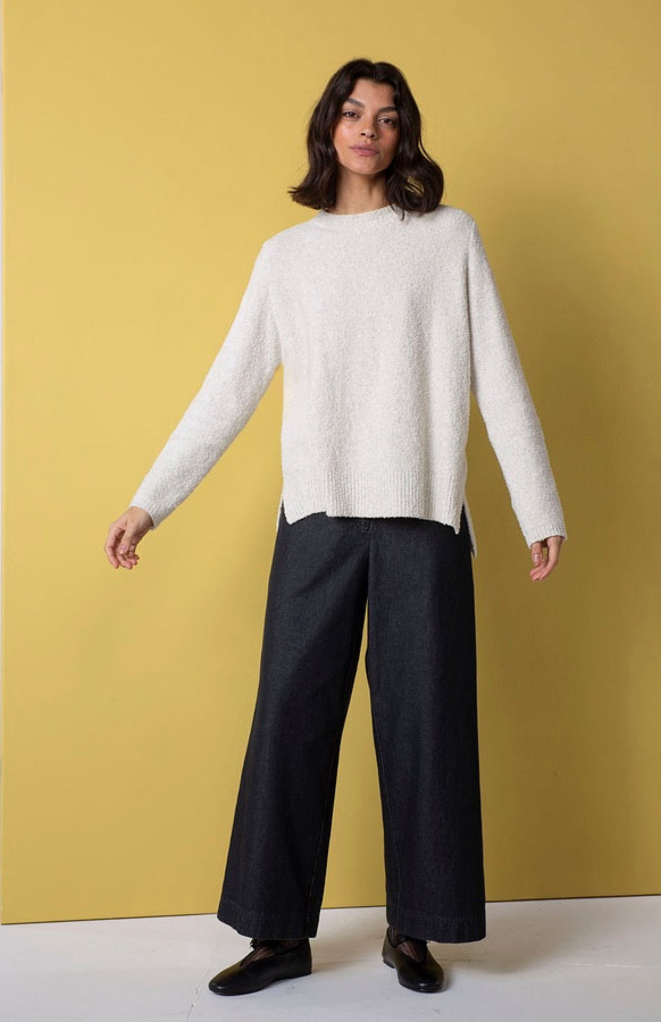 Women's wide leg pant with flat front button closure, curved front slash pockets and back patch pockets. Made in a denim fabric from Oska. In colour black. Full front view.
