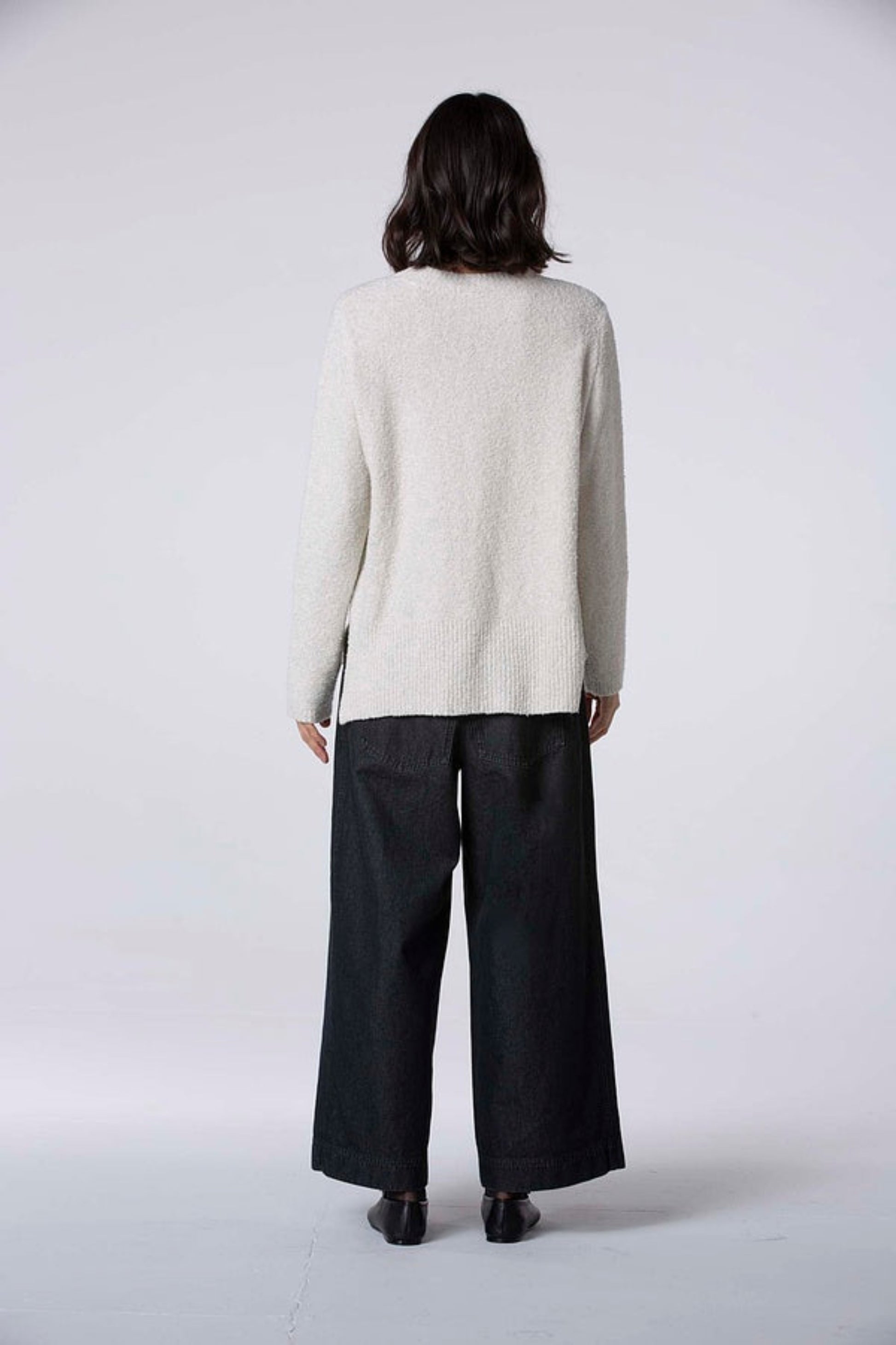 Women's wide leg pant with flat front button closure, curved front slash pockets and back patch pockets. Made in a denim fabric from Oska. In colour black. Back view.
