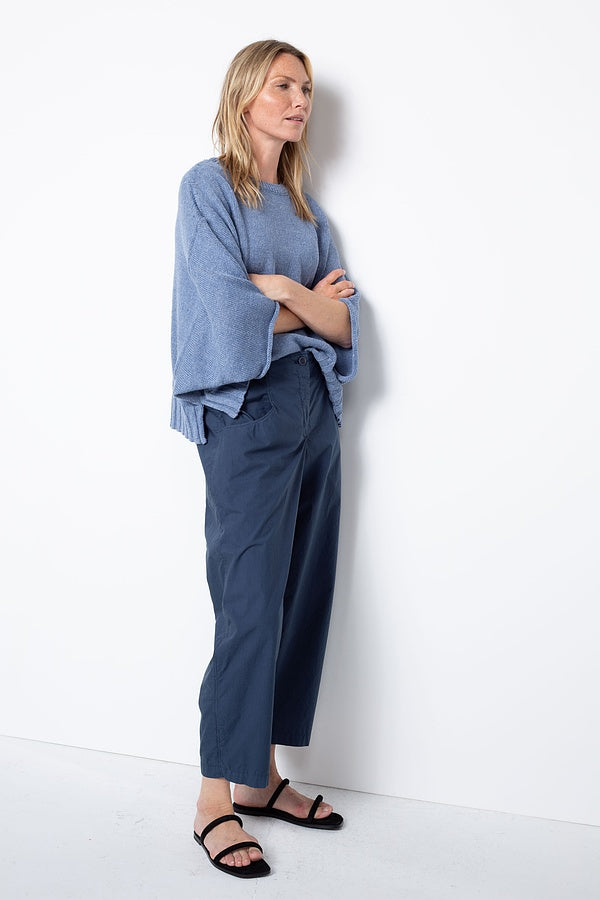 Women's ankle length, tapered  cropped pant with slash pockets, front button closure and elasticized waist at the back. Made in a cotton poplin by Oska. Side view.