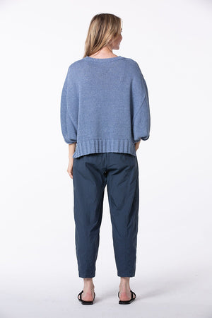 Women's ankle length, tapered  cropped pant with slash pockets, front button closure and elasticized waist at the back. Made in a cotton poplin by Oska. Back view.